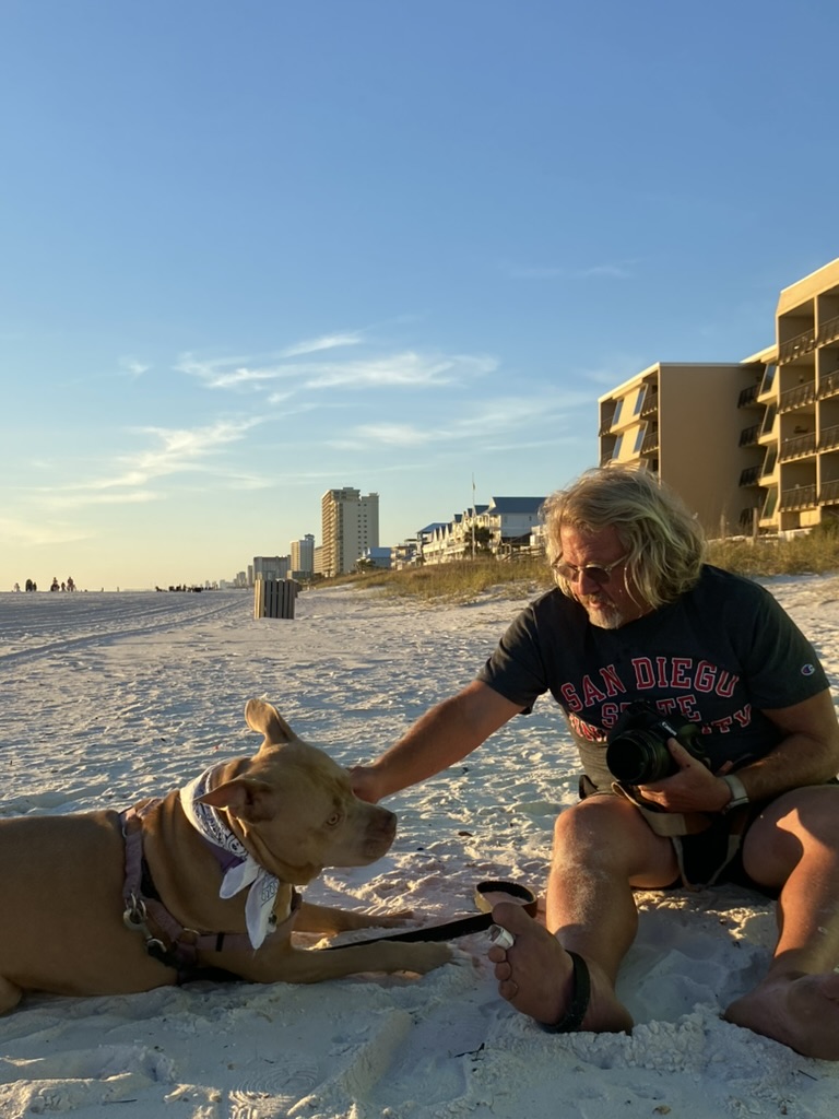 Ed Gutentag with his camera and dog on the beach at Panama City Beach