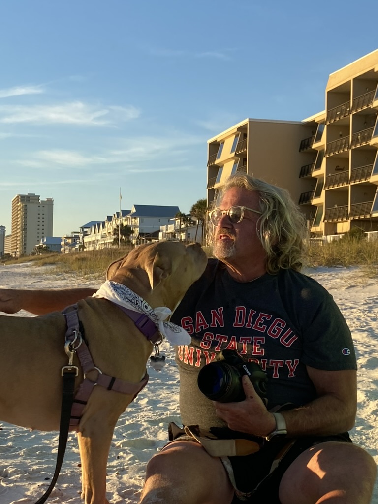 Ed Gutentag, a dog person, with a friendly dog at golden hour on the beach, Panama City Beach