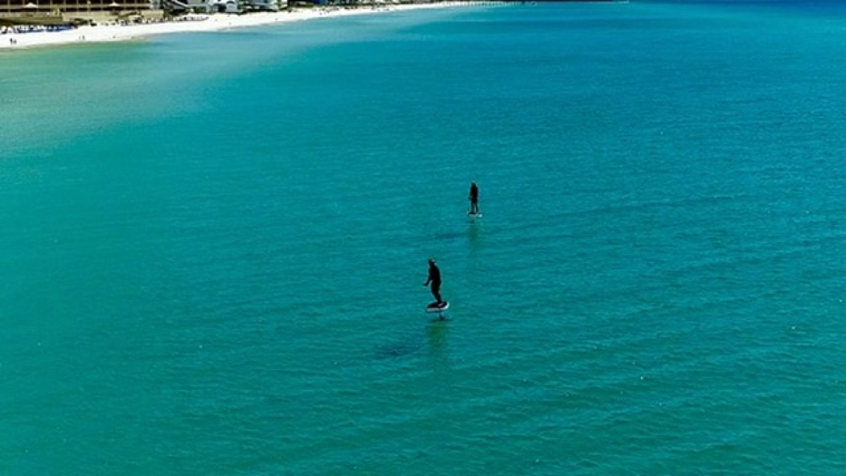 Cinematic aerial of surfers in the Gulf, Emerald Coast